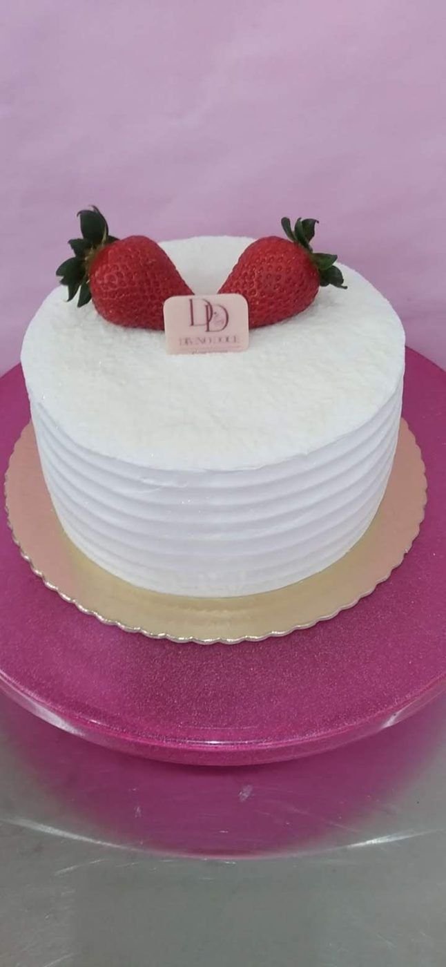 Bolo branco com dois morangos e a plaquinha Divino Doce